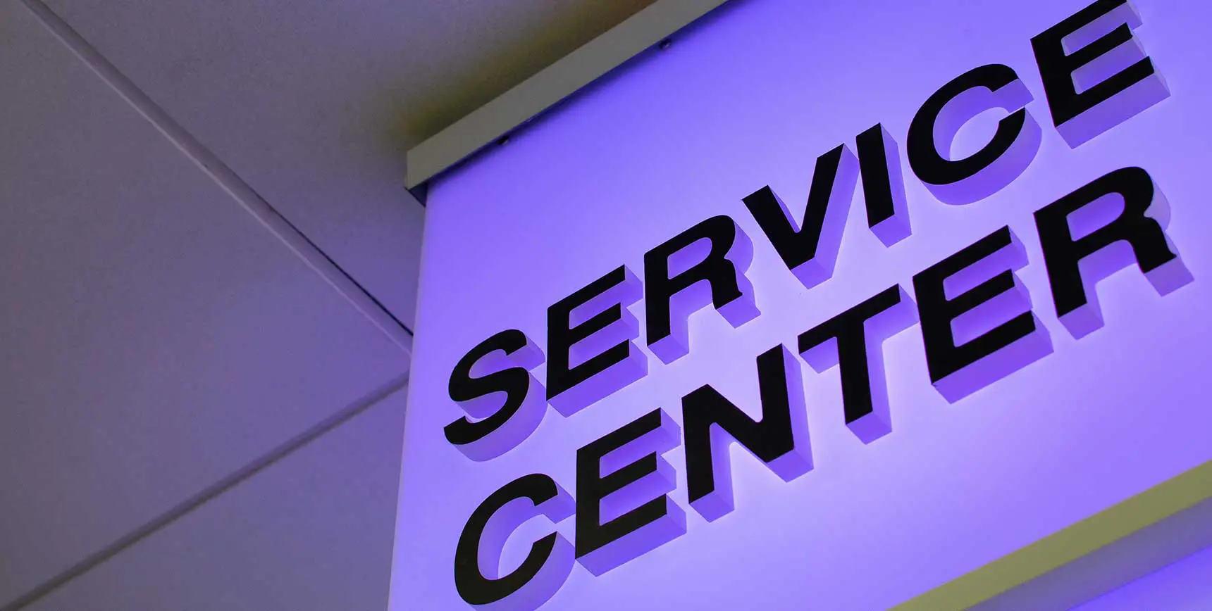 A service center sign lit up in the dark.