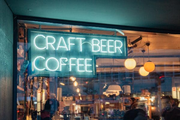 A neon sign that says craft beer coffee.