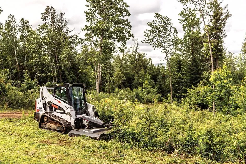 A white and black tractor is in the grass