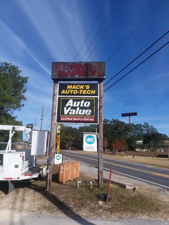 A truck parked on the side of the road near a sign.