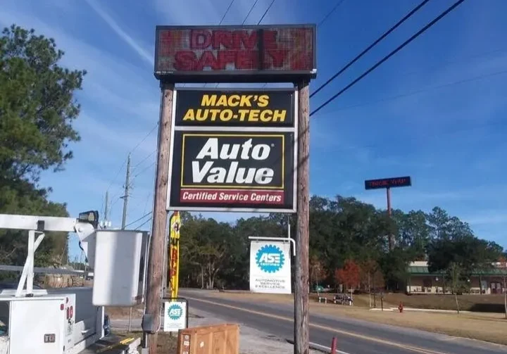 A truck parked on the side of the road near a sign.